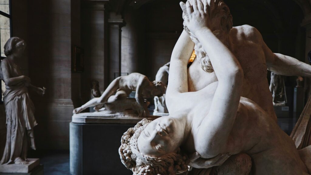 en noir et blanc deux statues d'un homme attaquant une femme